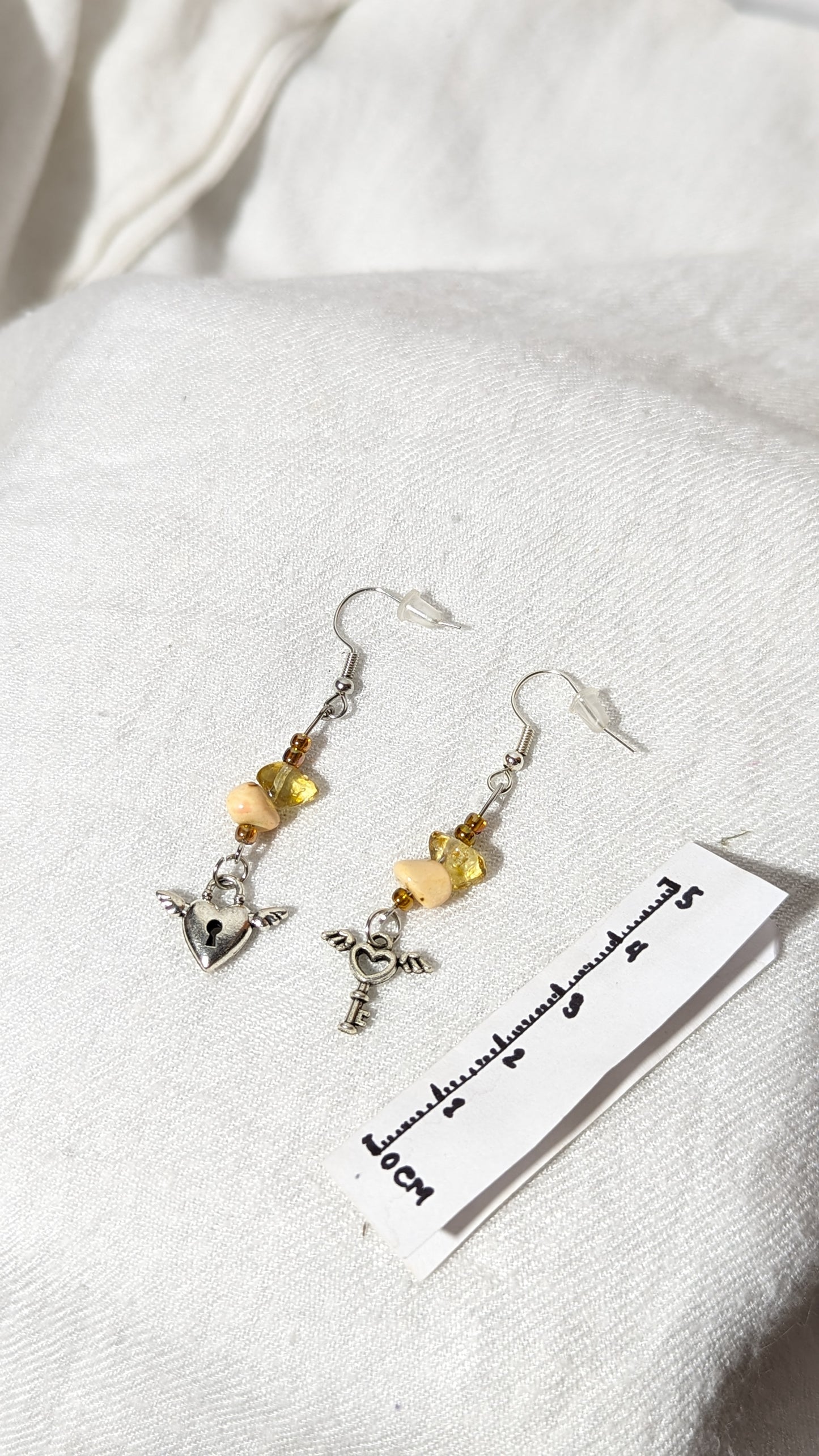 Beige crystal/gem earrings with “Key to the heart” pendant